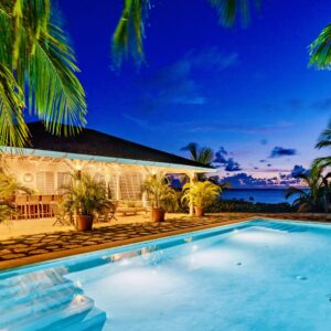 A swimming pool at the night with the ocean in front